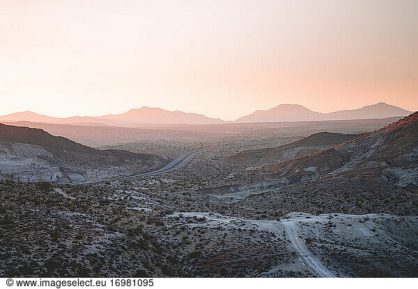 Wüstenautobahn unter pastellfarbenem Sonnenuntergang