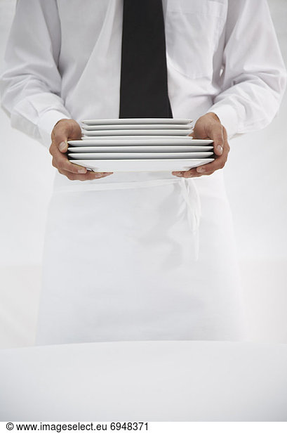 Waiter Holding Stack of Plates
