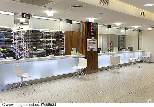 Waiting area and reception desk at a modern hospital  with signs and electronic display