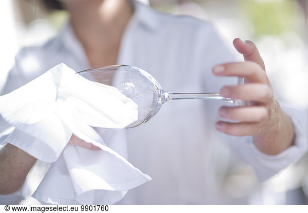 Waitress cleaning a wine glass with a cloth
