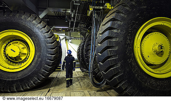 Walking past tires under drill rig in Alaska