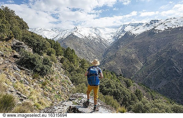 Wanderer auf einem Wanderweg  Wanderweg Vereda de la Estrella  hinten Sierra Nevada mit Gipfel Mulhacén und Pico Alcazaba  schneebedeckte Berge bei Granada  Andalusien  Spanien  Europa
