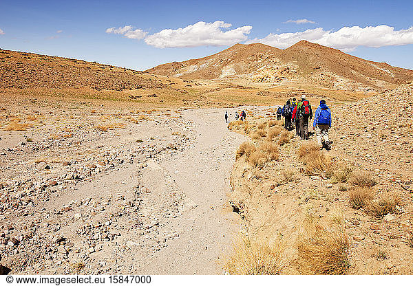 Wanderer durchqueren ein ausgetrocknetes Flussbett im Anti-Atlas-Gebirge in Marokko  Nordafrika. In den letzten Jahren sind die Niederschlagsmengen infolge des Klimawandels um rund 75% zurückgegangen. Dies hat l