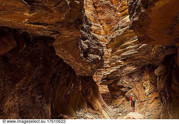 Wanderer in einem Slot Canyon  der Sandsteinschichten und Erosion beobachtet.