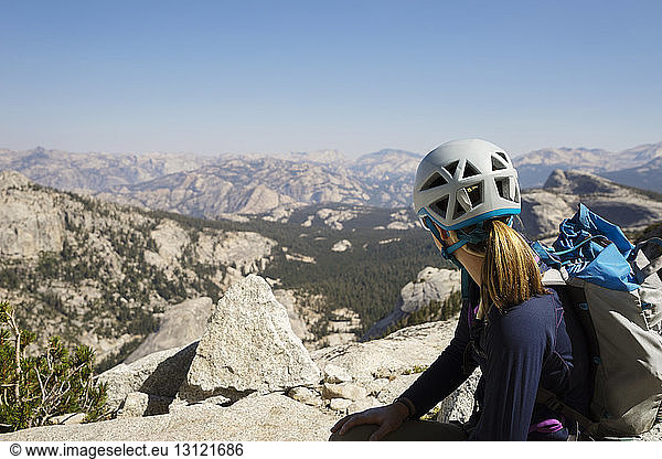 Wanderer sitzt auf einem Berg und schaut auf die Aussicht