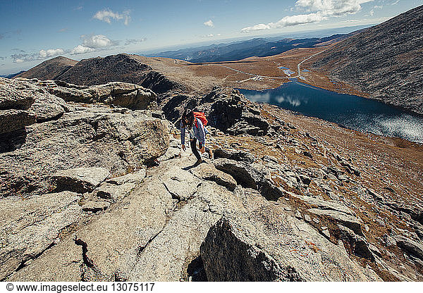 Wanderin besteigt Berg an sonnigem Tag
