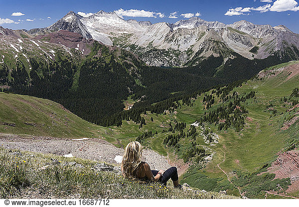 Wanderin betrachtet die Aussicht beim Entspannen auf einem Berg