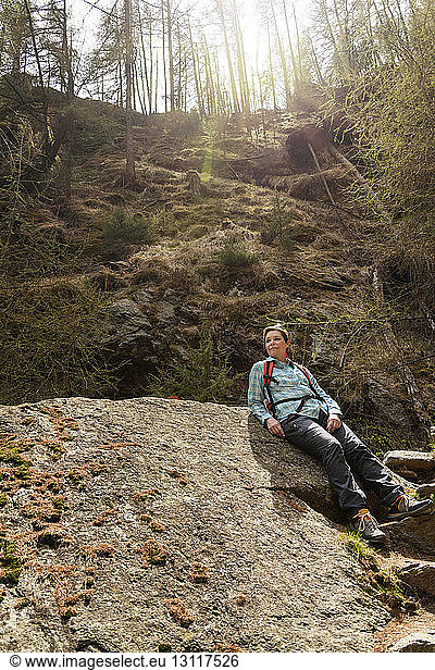Wanderin entspannt sich am Fels
