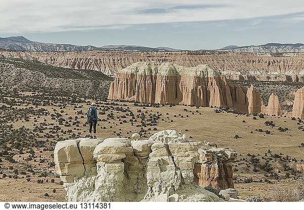 Wanderin in voller Länge auf Felsformation in der Wüste stehend
