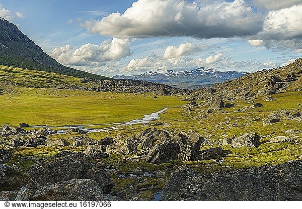 Wanderweg im K?rkevagge  Schwedisch-Lappland  mit großen Felsen und schwimmendem Fluss und Bergen im Hintergrund und bewölktem Wetter  Bezirk Kiruna  Schwedisch-Lappland  Schweden.