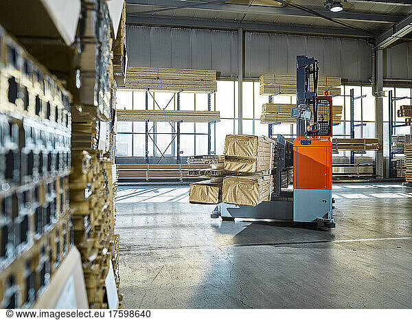 Warehouse worker operating forklift in industrial building