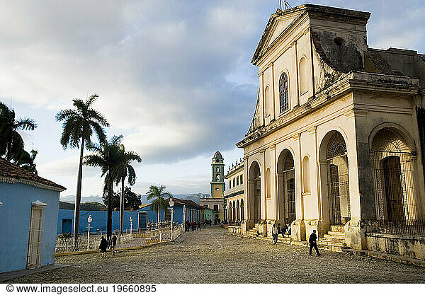 Warm light falls on colonial cathedral in small town square  Trinidad  Cuba.