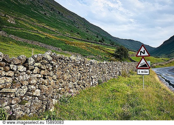 Warnschild mit 20 % Steigung für Autofahrer  Kirkstone Pass  Lake District National Park  Cumbria  England. Die Straße ist lokal als The Struggle bekannt und der Nationalpark gehört zum UNESCO-Weltkulturerbe.