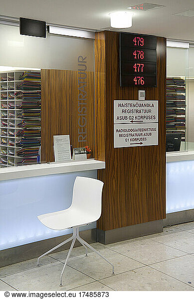 Wartebereich und Empfangsschalter in einem modernen Krankenhaus  mit Schildern und elektronischer Anzeige
