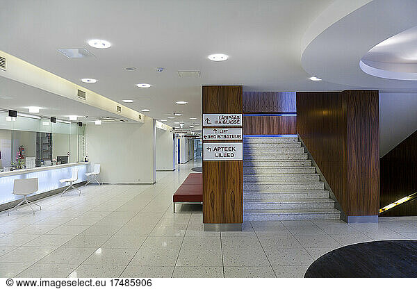 Wartebereich und Empfangsschalter in einem modernen Krankenhaus  mit Schildern und Treppen