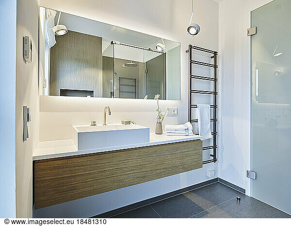 Wash basin with mirror mounted on wall in apartment