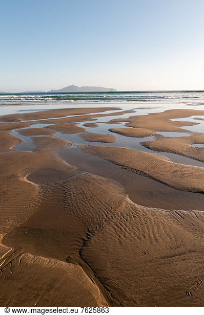 Wasserbildungsmuster im Sand am Strand