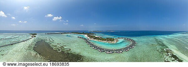 Water bungalows on Kanuhura Island under blue sky in Maldives
