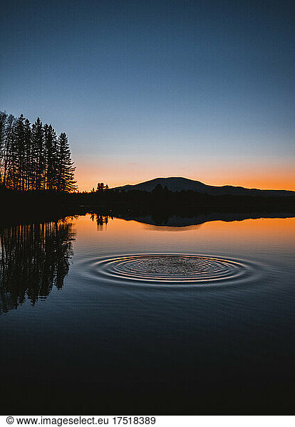 water ripples in circles on flagstaff lake  Maine at sunset