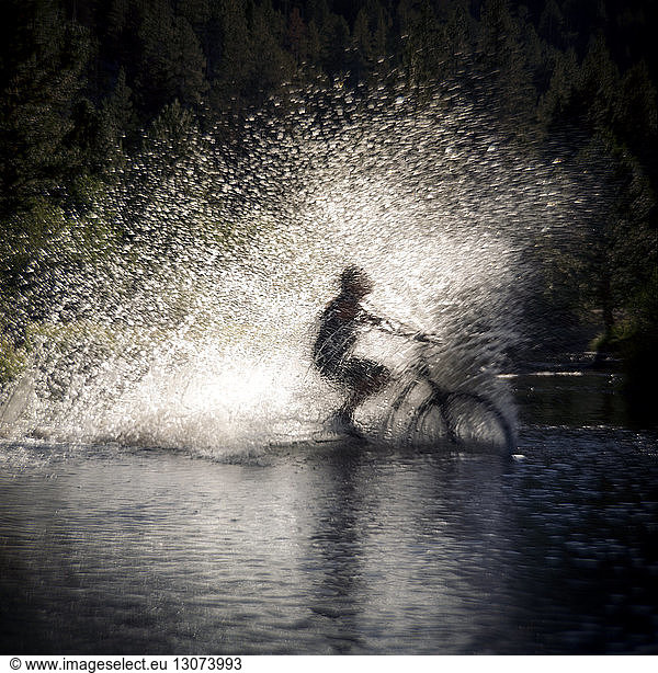 Water splashing while person cycling in puddle