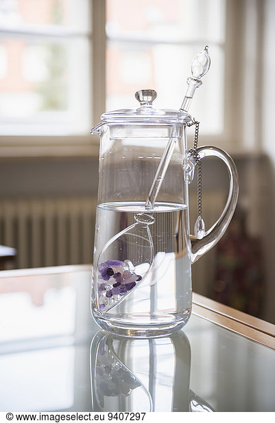Water with gemstones in pitcher in kitchen
