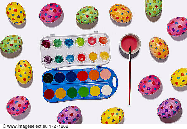 Watercolor paints and colorful spotted Easter eggs
