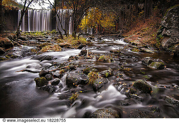 Waterfall and creek in a beautiful autumn day