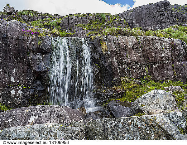 Waterfall over a rocky  rugged ridge; Cloghane  County Kerry  Ireland