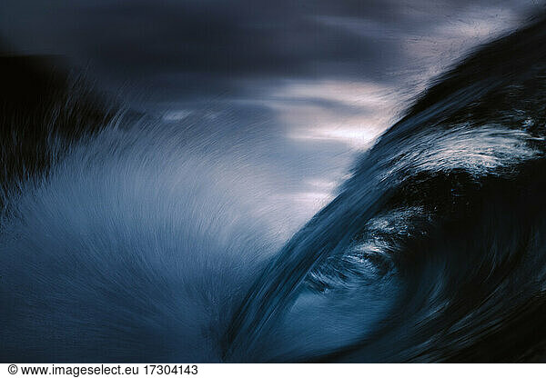 wave breaking with slow shutter under clouds
