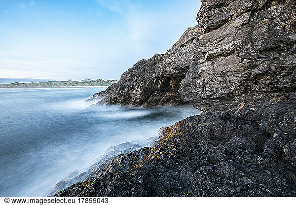 Waves crashing on rock formations by Fairy Bridge in sea