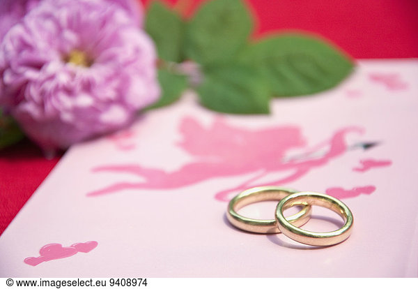 Wedding rings on wedding card with roses  close up