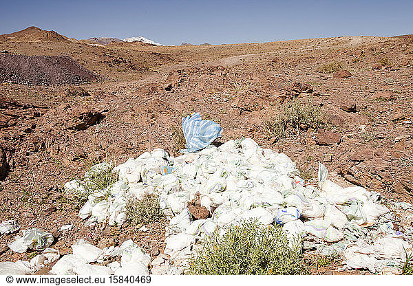 Weggeworfene Wegwerfwindeln am Rande des Berberdorfes Tamazight in der Nähe von Jebel Sirwa im Anti-Atlas-Gebirge in Marokko  Nordafrika. Die Elektrizität ist gerade erst hierher gekommen.