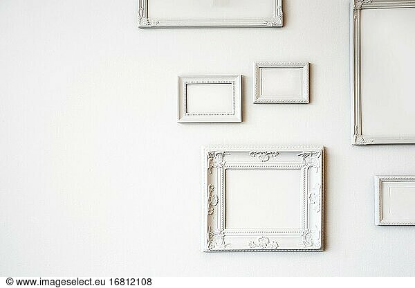 Weiß verschiedene antike leere Foto- oder Bilderrahmen auf der weißen Wand modernes Design  minimale Innenarchitektur  Kopierraum oder Platz für Text Großaufnahme.
