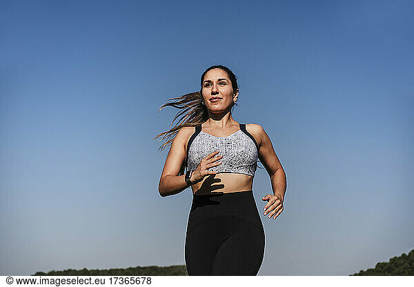 Weibliche Athletin läuft bei Sonnenuntergang