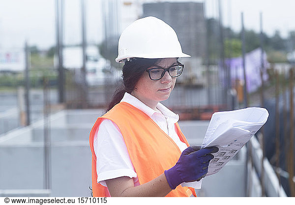 Weibliche Bauingenieurin betrachtet Bauplan