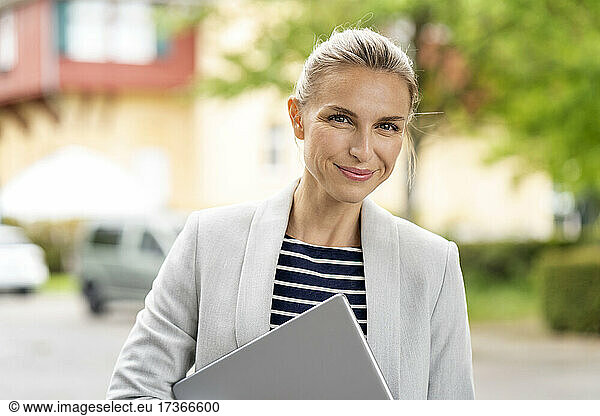 Weibliche Fachkraft in Business Casual hält digitales Tablet