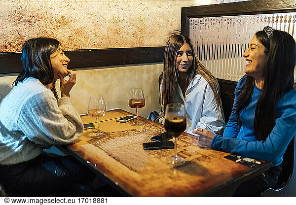 Weibliche Freunde unterhalten sich bei einem Drink in einer Bar