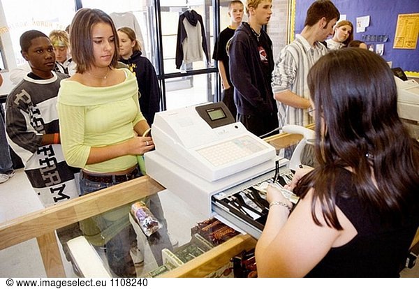 Weibliche High-School-Schüler zahlt für Schulmaterial zu einem Buch-Shop