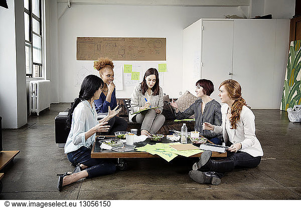 Weibliche Kollegen diskutieren über Strategie im kreativen Büro