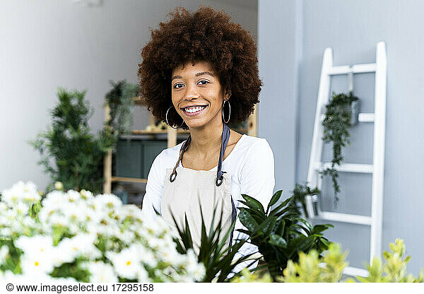 Weibliche Ladenbesitzerin lächelt im Pflanzenladen