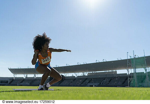 Weibliche Leichtathletin wirft Kugelstoßen im sonnigen Stadion