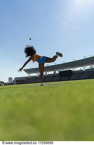 Weibliche Leichtathletin wirft Kugelstoßen im sonnigen Stadion