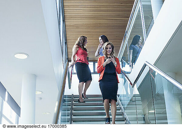 Weibliche Mitarbeiter  die die Treppe im Büro hinuntergehen
