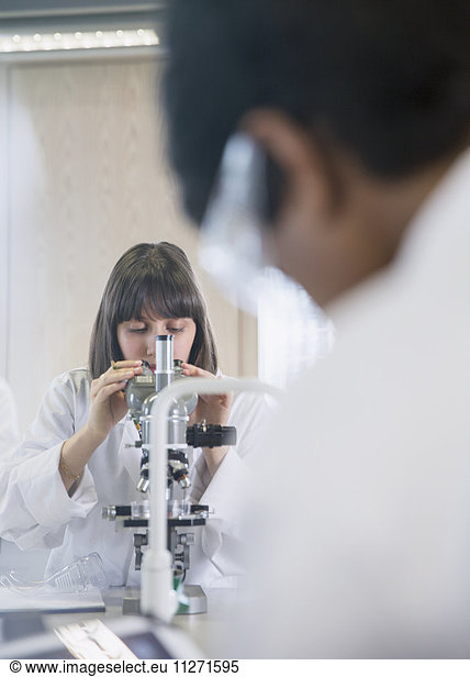 Weibliche Studentin  die ein wissenschaftliches Experiment im Klassenzimmer des Wissenschaftslabors durchführt
