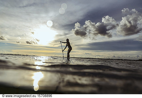 Weibliche SUP-Surferin bei Sonnenuntergang  Bali  Indonesien