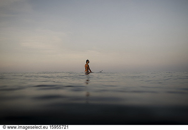 Weibliche Surferin auf dem Surfbrett am Abend  Costa Rica