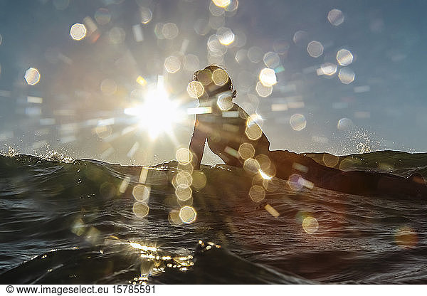 Weibliche Surferin auf dem Surfbrett gegen die Sonne  Bali  Indonesien