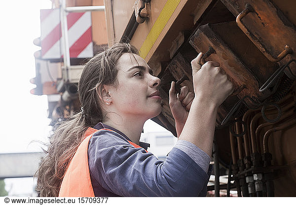 Weibliche Technikerin untersucht Lastwagen