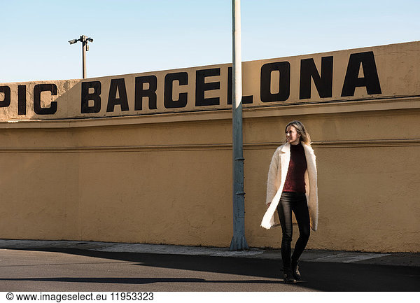 Weibliche Touristin bei einem Mauerspaziergang mit Barcelona in Großbuchstaben  Barcelona  Spanien