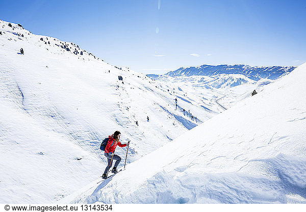 Weibliche Wanderin besteigt schneebedeckten Berg im Joshua-Tree-Nationalpark